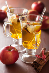 glass of mulled apple cider with orange and spices, winter drink
