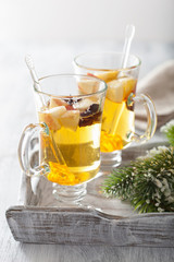 glass of mulled apple cider with orange and spices, winter drink