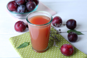 Delicious plum juice with fruits on wooden table close up