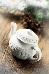 Christmas concept: white tea pot on wooden table