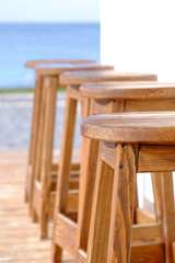 Beach bar wooden stools in a row, close up