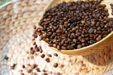 Roasted coffee beans scatter from wattled basket into the other one