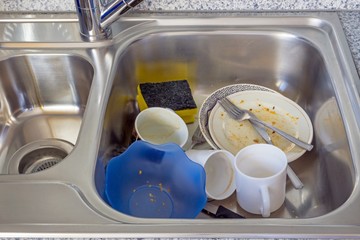 Fototapeta na wymiar A small pile of dirty dishes in a kitchen sink