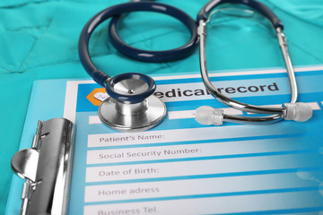 Medical stethoscope and clipboard on blue background
