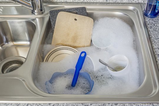 Dirty dishes in soapy water in a kitchen sink