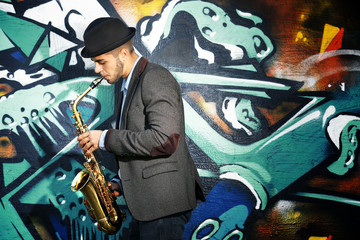 Saxophone player on graffiti wall background