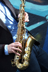 Obraz premium Saxophonist plays jazz on the street, close up
