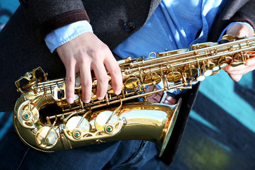Saxophonist plays jazz on the street, close up