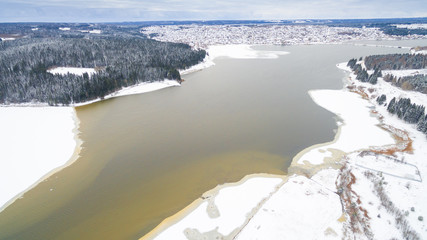winter aerial photo of the river, forests and grey sky with cloud