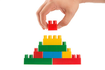 Naklejka premium hand building up a wall by stacking up Bricks, business conception