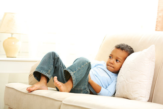 Little boy sitting on sofa in the room