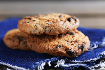 Cookies with chocolate crumbs on wooden table against blurred background, close up