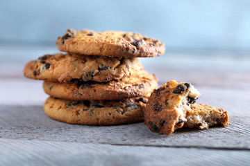 Close up focus view on cookies with chocolate crumbs on wooden table against blurred blue background