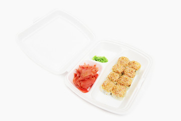 Japanese rolls in a restaurant with fish and vegetables in container box isolated on white background