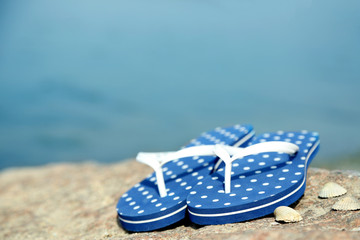 Obraz premium Bright flip-flops on stone, nature background