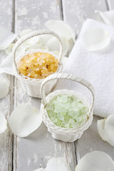 Sea salt in wicker baskets among white rose petals