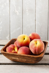 Bowl of peaches on rustic wooden table