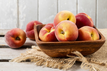 Bowl of peaches on rustic wooden table