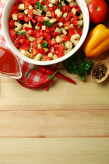 Ratatouille before cooking and ingredients, on wooden background