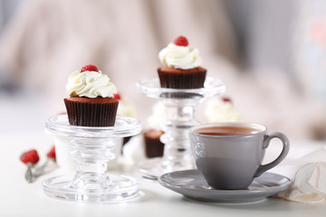 Beautiful chocolate cupcakes with cream and raspberry on table