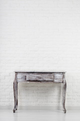 Empty wooden table over white brick wall