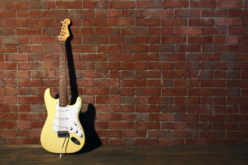 Fototapeta na wymiar Guitar on brick wall background