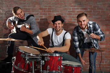 Fototapeta na wymiar Musicians playing the drums on brick wall background