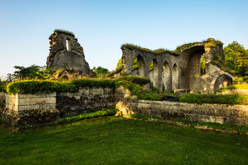 Fototapeta premium Ruins of Alvastra Monastery, Sweden. Ancient buildings on the farmland right beside the hills of Omberg in erarly morning light