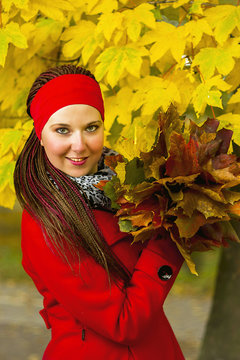 Fototapeta Woman with colorful leaves in hairstyle with braids