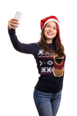 Young girl with a christmas hat taking a selfie isolated on whit