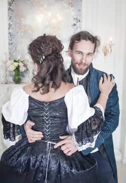 Handsome Man Untying Corset Of Woman In Medieval Dress