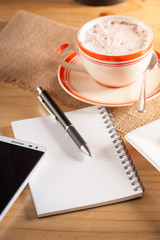 Notebook with pen on wood table