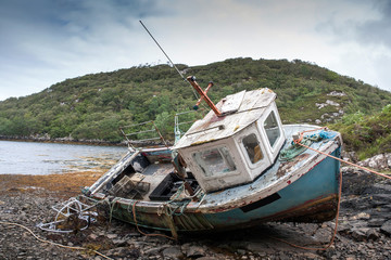 abandoned fishing boat lying on a rocky beach on the Isle of Lewis, Outer Hebrides, Scotland, UK, Europe  - 94866531