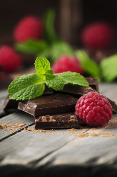 Dark chocolate with mint and raspberry on the vintage table