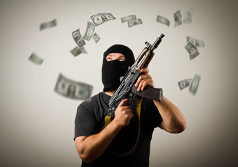 Man with gun and dollar banknotes.