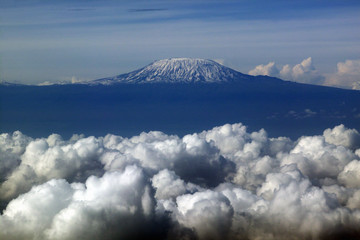 Aerial image of Mount Kilimanjaro, Africa's highest mountain, with snow and white puffy clouds from Kenya