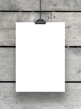 One hanged paper frame with clip on grey wooden boards background