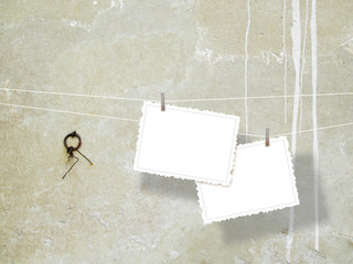 Two hanged cardboards with clothes pins on stained concrete wall background