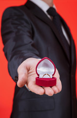Young man holding a golden ring in the box