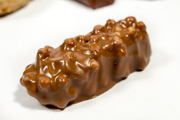 Chocolate bar with round chunks of almonds, on white. Spanish Christmas sweet