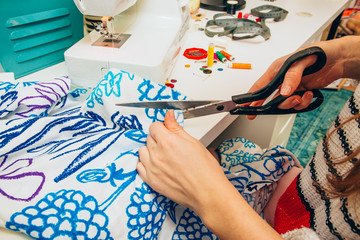 Junge Frau n&auml;ht an einer N&auml;hmaschine ein Kleidungsst&uuml;ck