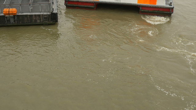 River barge is making maneuvers near pier.