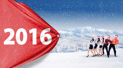 Businesspeople pulling numbers 2016 on a banner