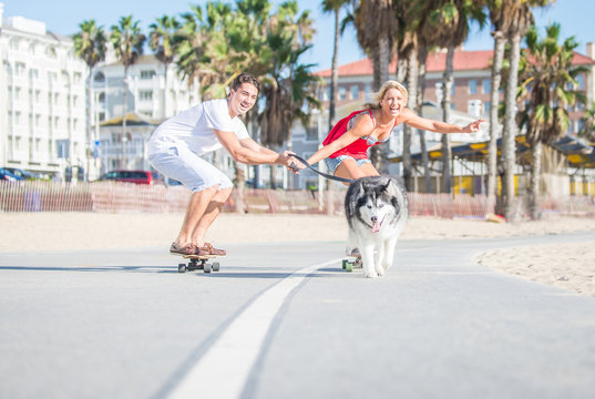 Happy couple and their husky dog making sport