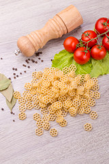 Pasta, tomatoes and pepper on a wooden background