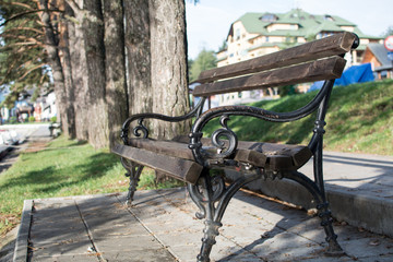 Iron park bench in the city park, besides lake