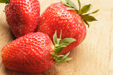 Red fresh strawberry fruits on wooden table.