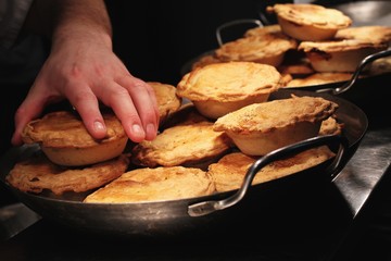 chef putting pies into pans
