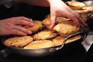 chef putting pies into pans