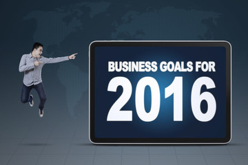 Man jumping while pointing at business goals for 2016